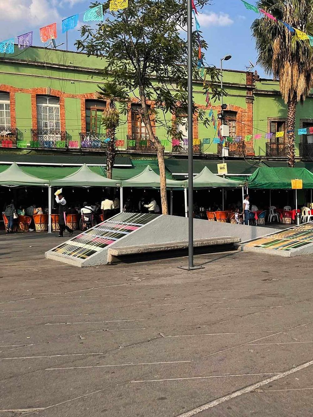 Colorful street scene with vibrant building, outdoor dining, and lively atmosphere, ideal for QuestForDirections.