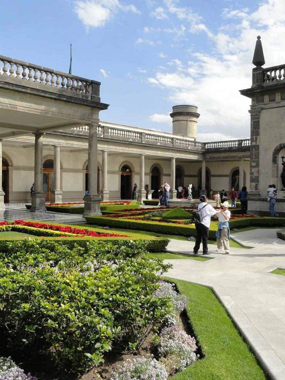 Elegant historic building with lush garden, perfect for travelers seeking guided tours and sightseeing.