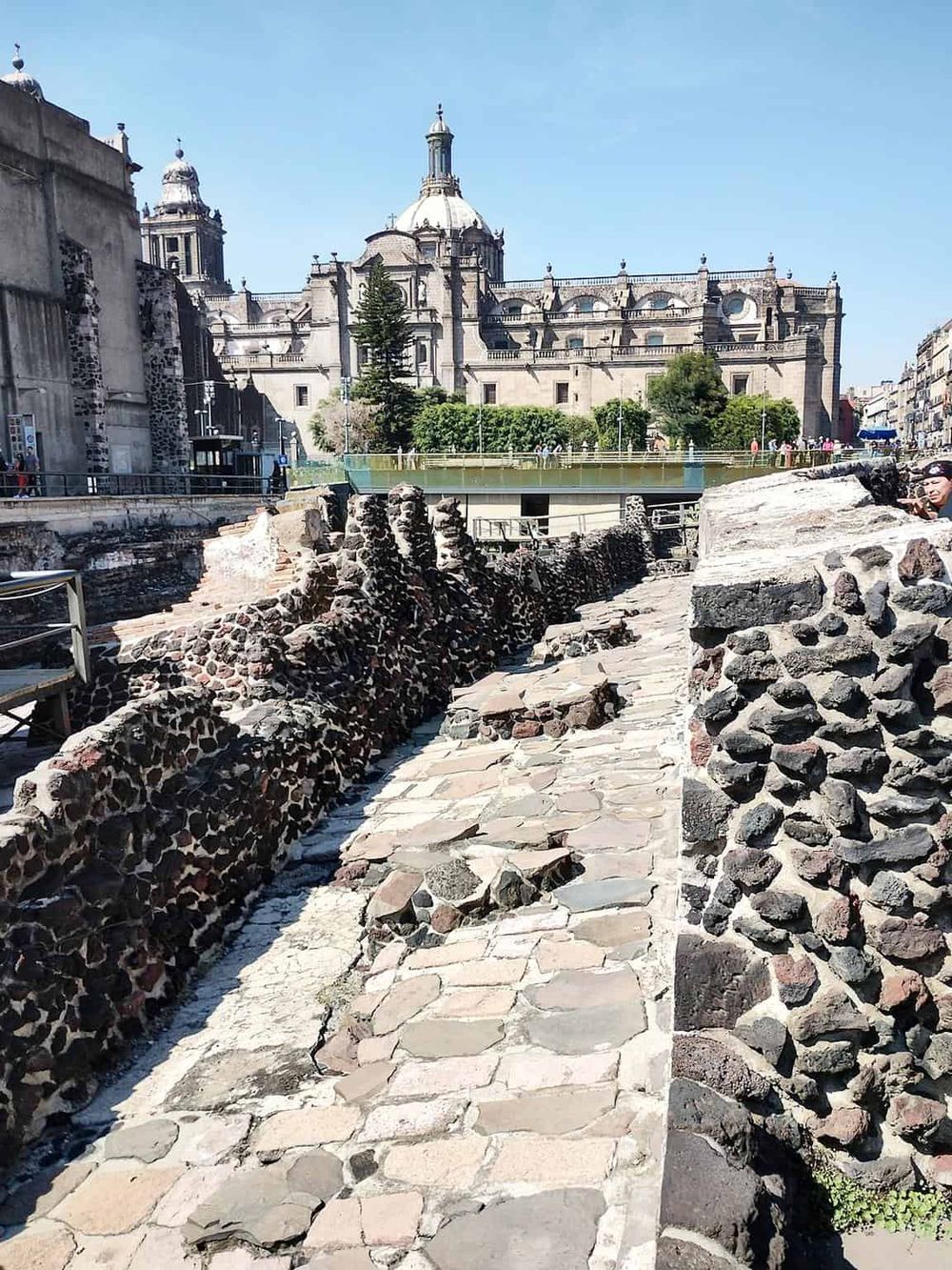 Ancient stone ruins in front of a historic church, showcasing archaeological sites and cultural heritage.