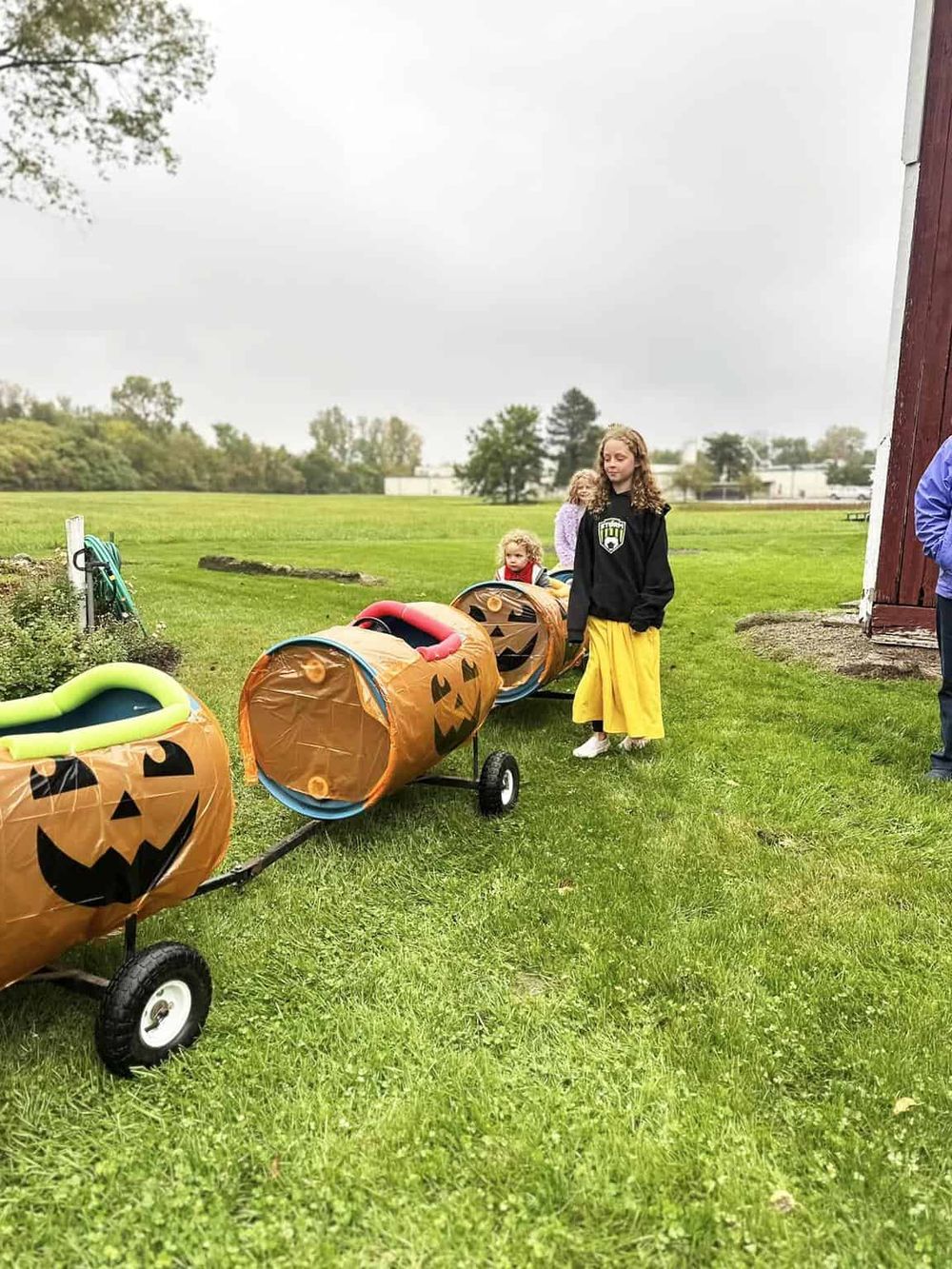 Colorful pumpkin-shaped Halloween trick-or-treat wagons on wheels.