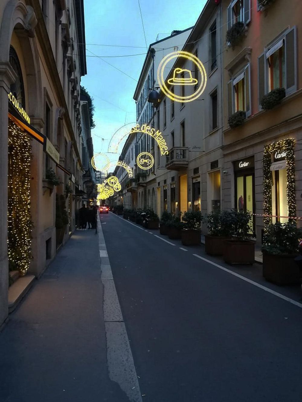 Neon street lights with shopping and fashion store signs on a charming city street.