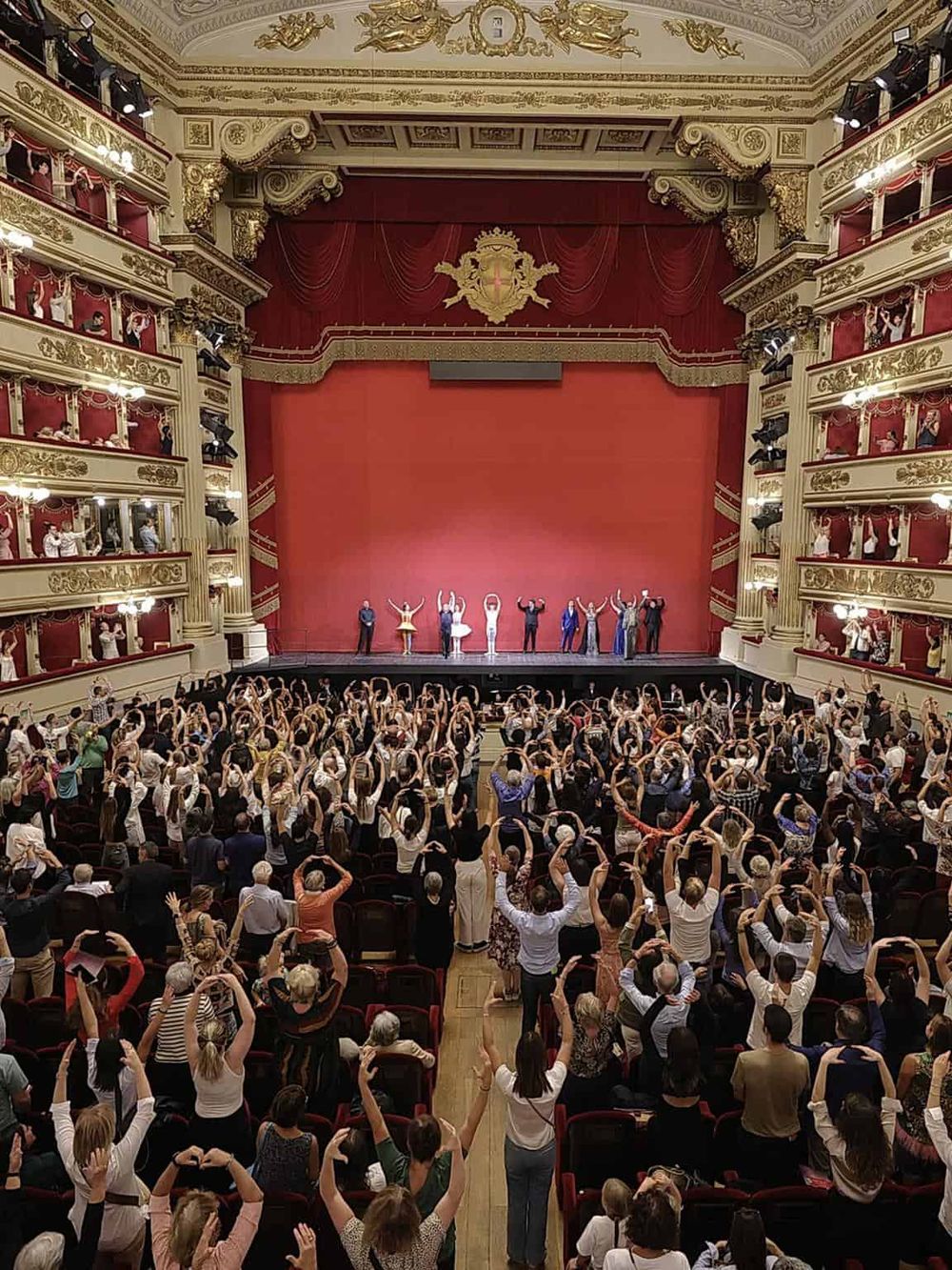 Avenue Theatre audience performing synchronized dance on stage, renowned for its live performances and cultural events.