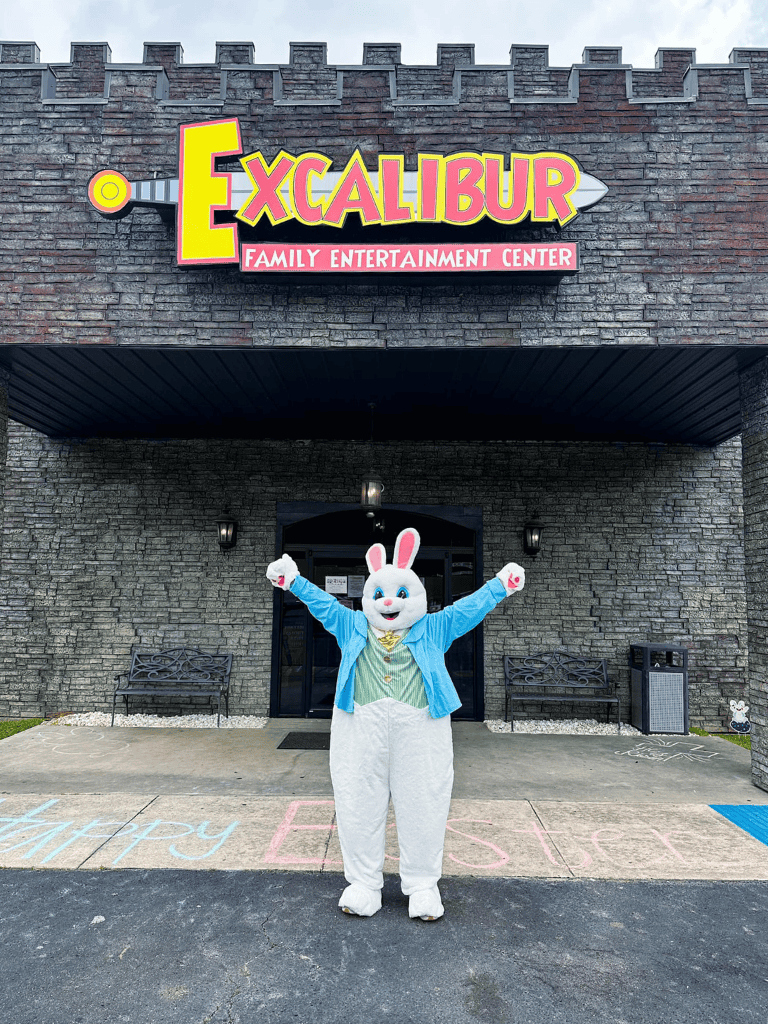 Colorful Excalibur Family Entertainment Center entrance with cheerful Easter bunny mascot for family fun.