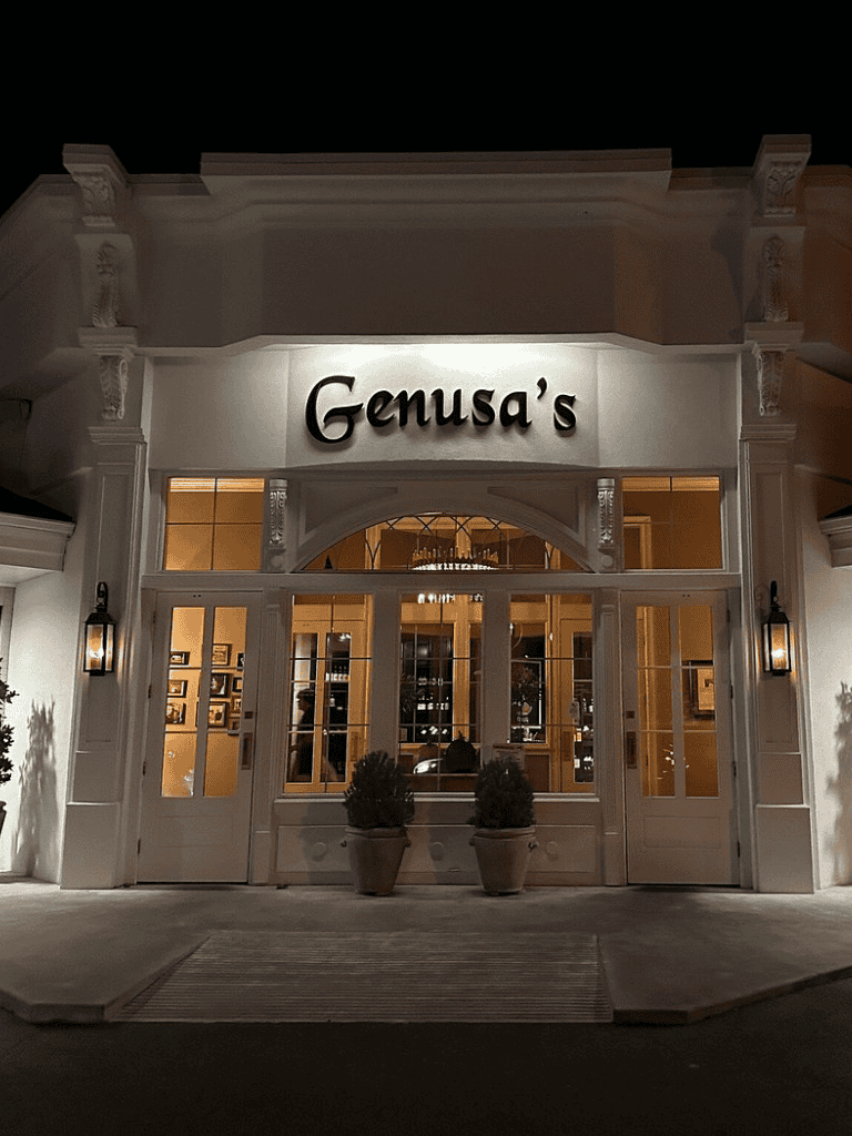 Elegant restaurant entrance at night with welcoming lighting and classic design.