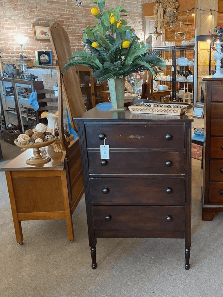 Antique dark wood dresser with four drawers and a decorative floral design, perfect for vintage home decor.