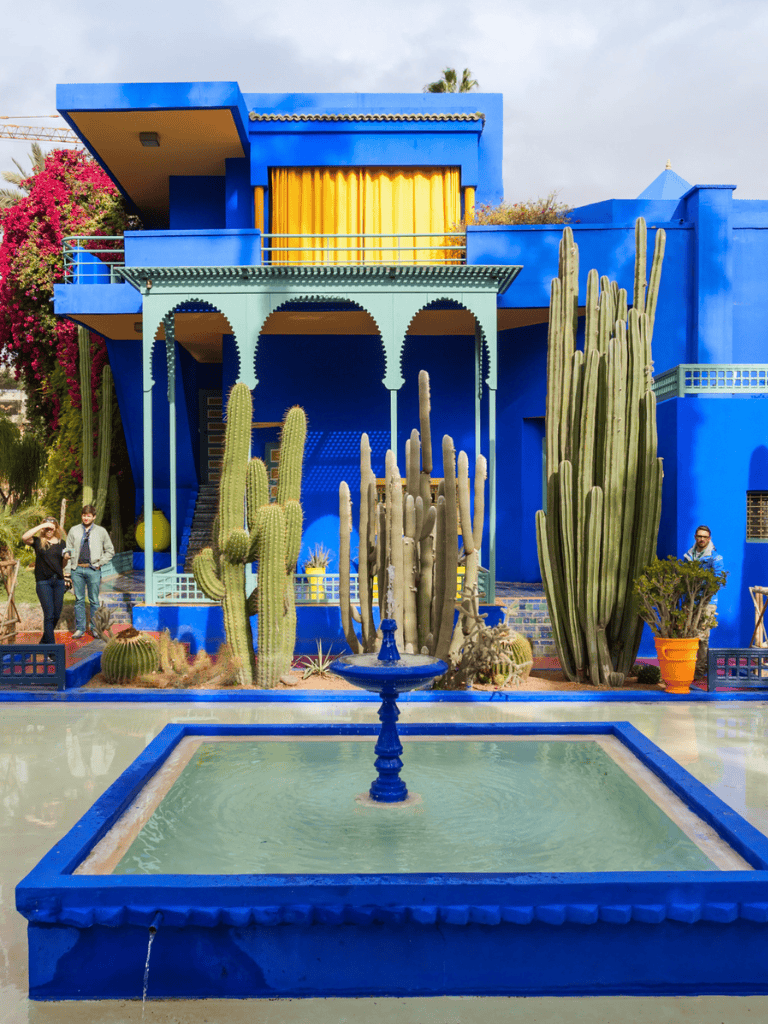 Blue Moroccan-style house with cacti, fountain, and vibrant yellow accents at QuestForDirections.