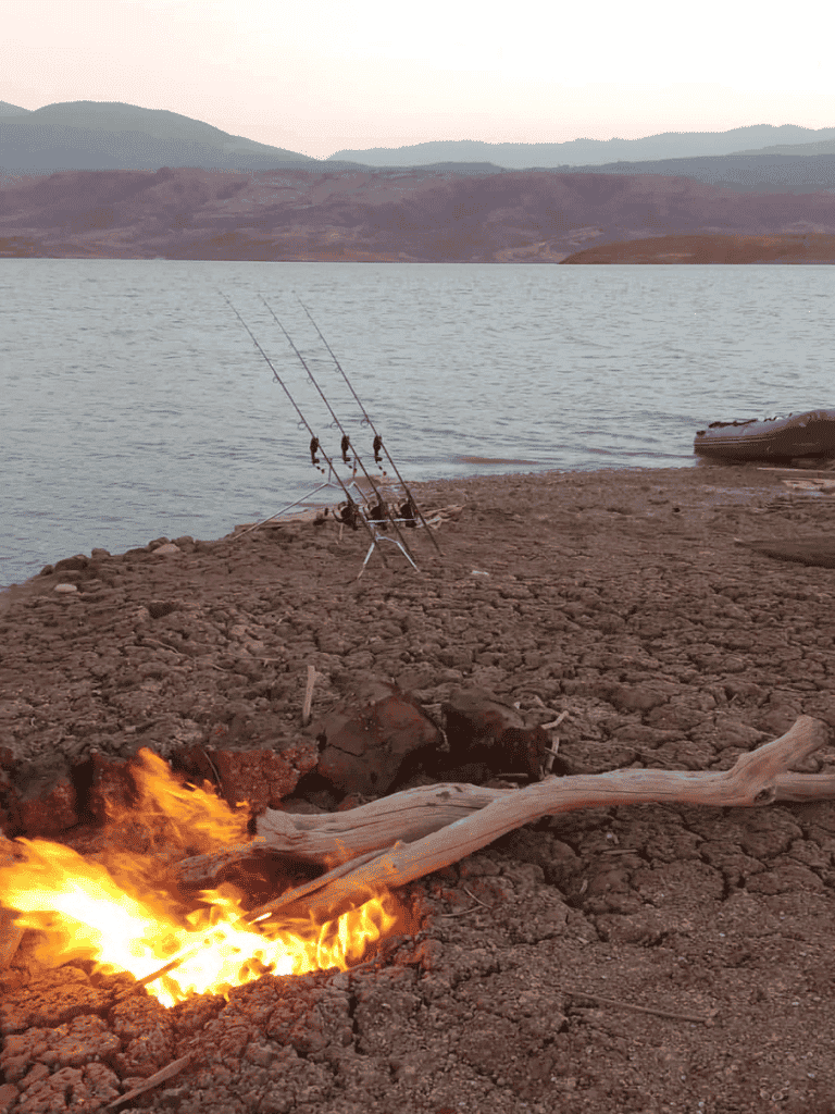 Fishing rods set up by the water at a scenic lakeside location.