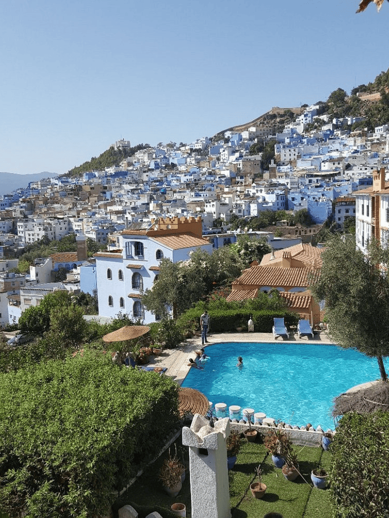 Stunning hillside view of a blue-and-white city with a pool in the foreground, perfect for travel and leisure.