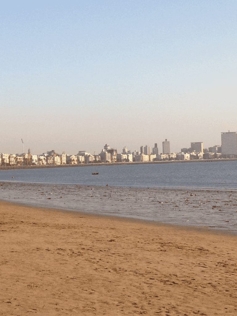 Beach city skyline view with sandy shore and water.