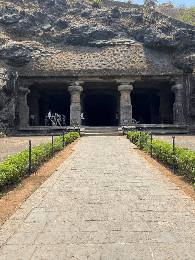 Ancient rock-cut cave with stone pillars at QuestForDirections archaeological site.