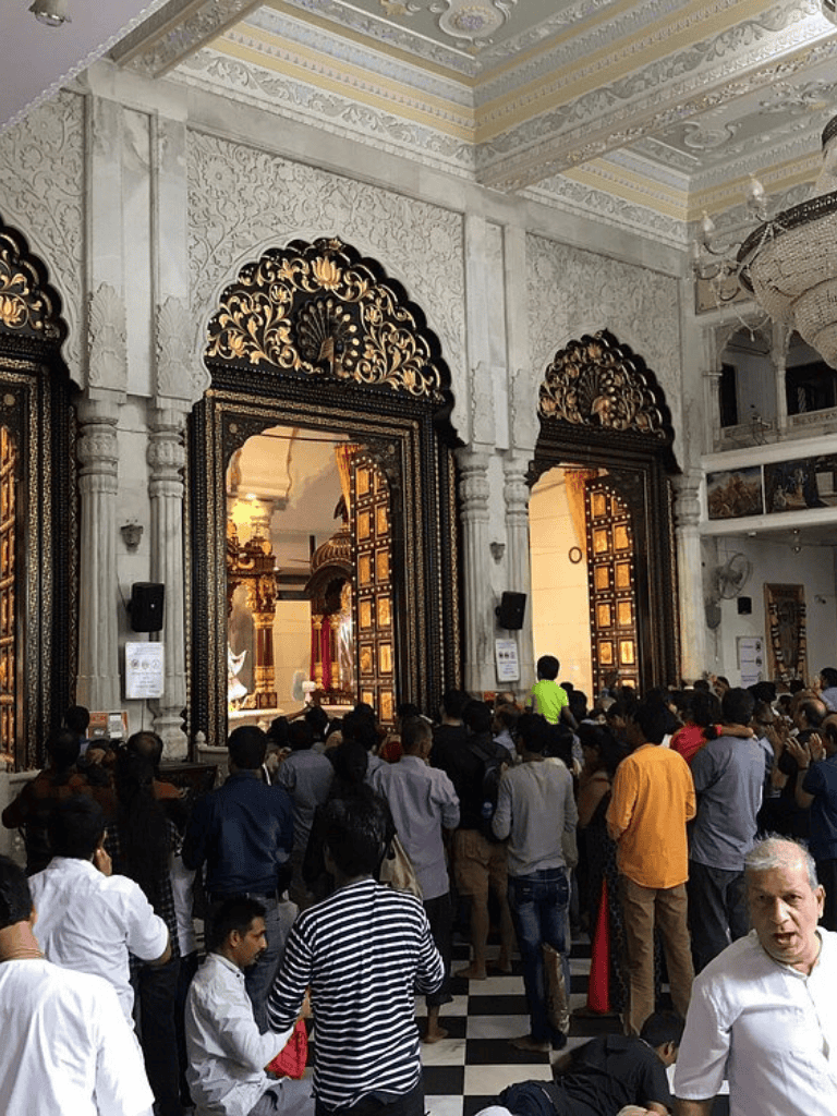 Intricate temple architecture with a crowd of visitors inside a historic Indian temple.
