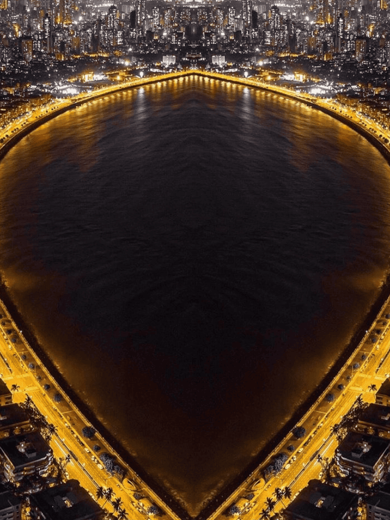 Vibrant night view of Miami Beach with illuminated coastline and city skyline reflect on the ocean waters.