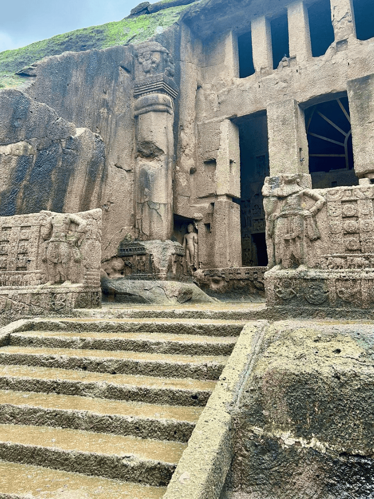 Ancient rock-cut temple with detailed carvings and stairway, located in QuestForDirections site.