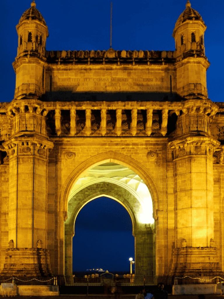Majestic historic gateway illuminated at night, showcasing intricate architectural details.