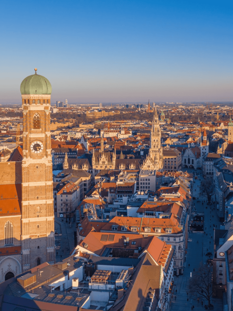 Ancient European cityscape with historic architecture, church towers, and scenic city views at sunset.