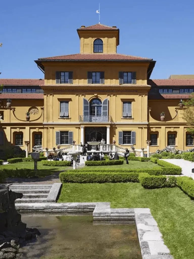 Elegant historic mansion with lush gardens and fountain, perfect for guided tours and photo opportunities.