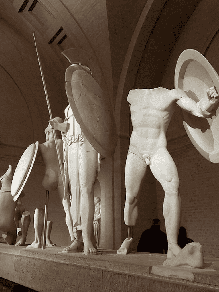 Athletic Greek statue sculptures displayed in museum exhibit, showcasing classical art and historical significance.