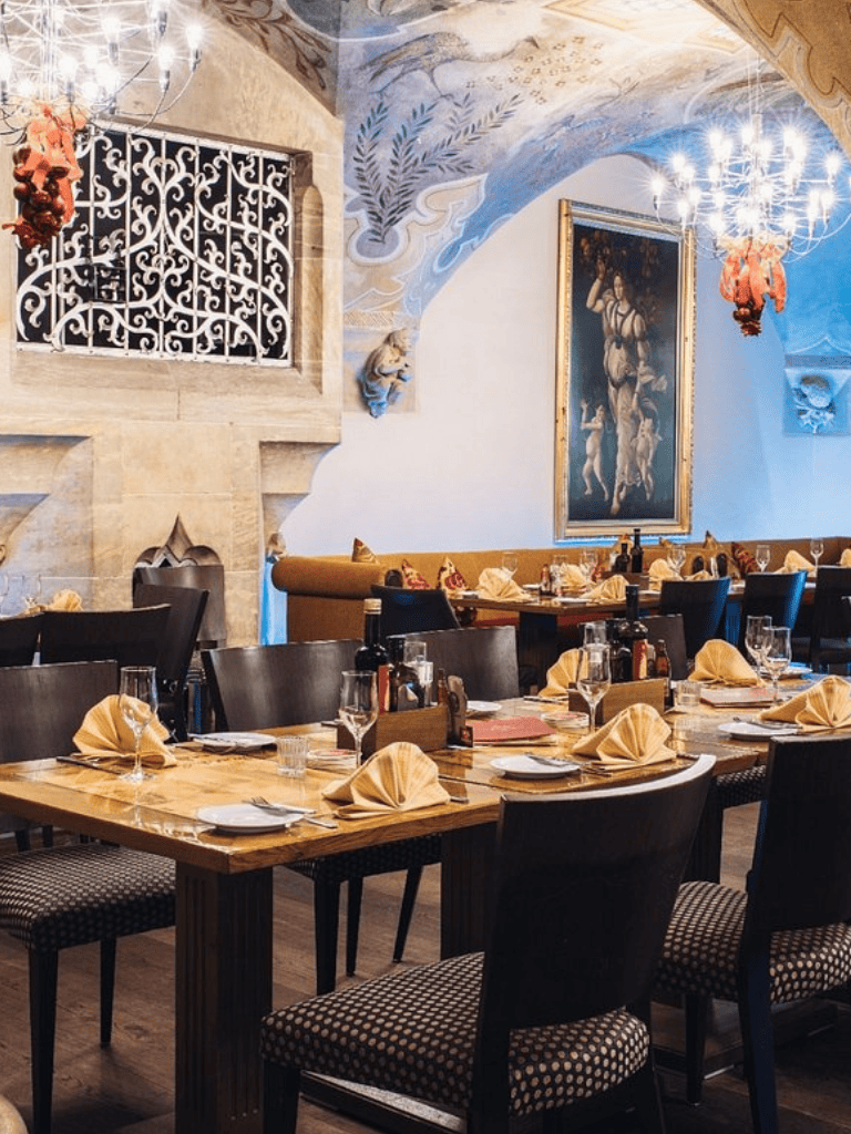 Elegant restaurant interior with historical decor and table settings for fine dining.