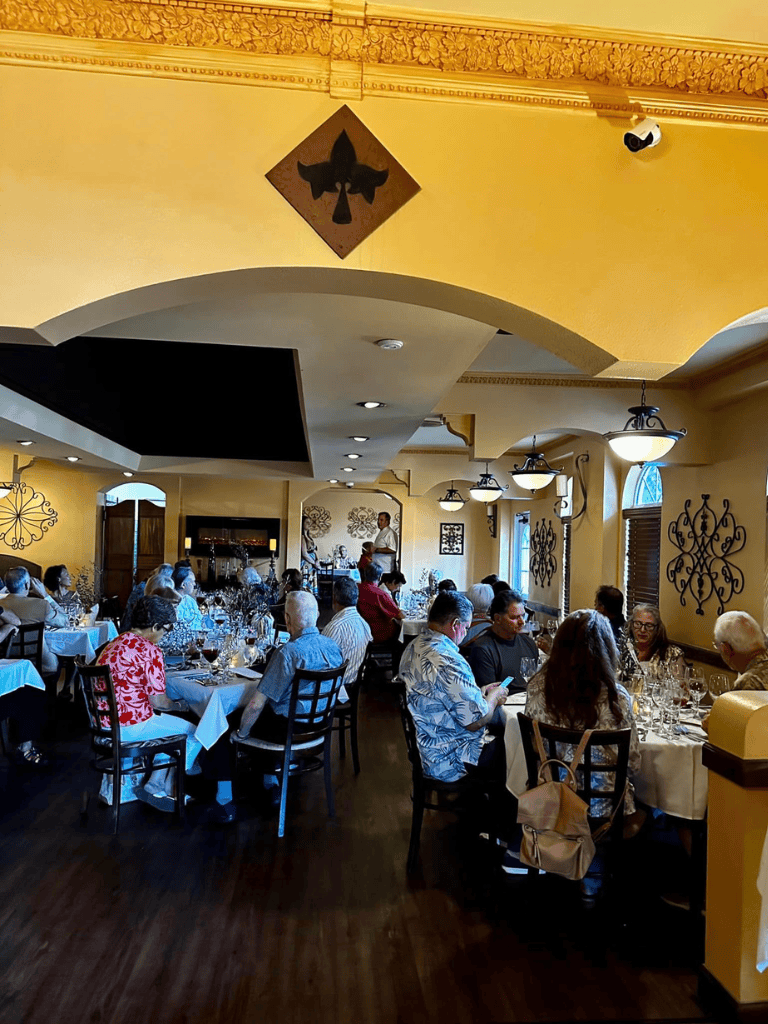 Elegant restaurant interior with guests dining and a chef in the background, showcasing quality dining experience.
