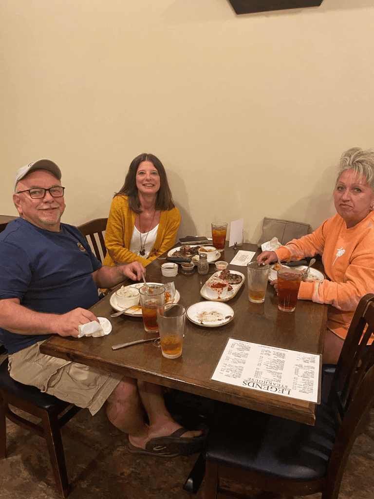 Enjoying a casual dinner with friends at a cozy restaurant, sharing meals and good conversation.