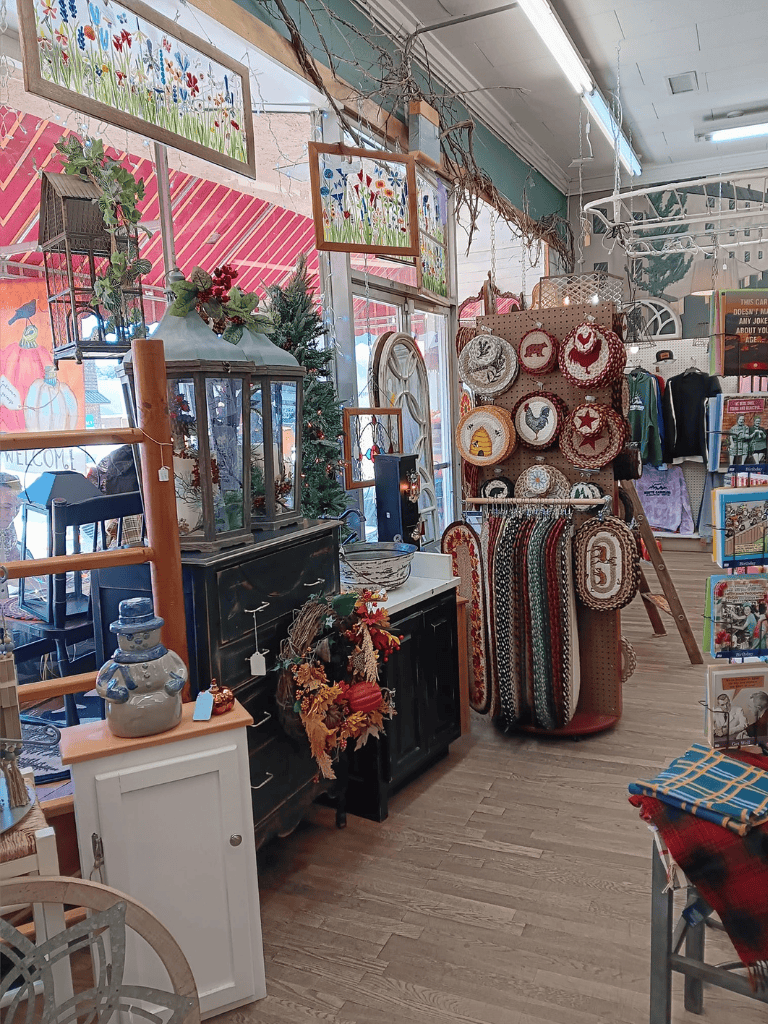 Colorful thrift store display with vintage décor, holiday wreaths, and handcrafted items for sale.