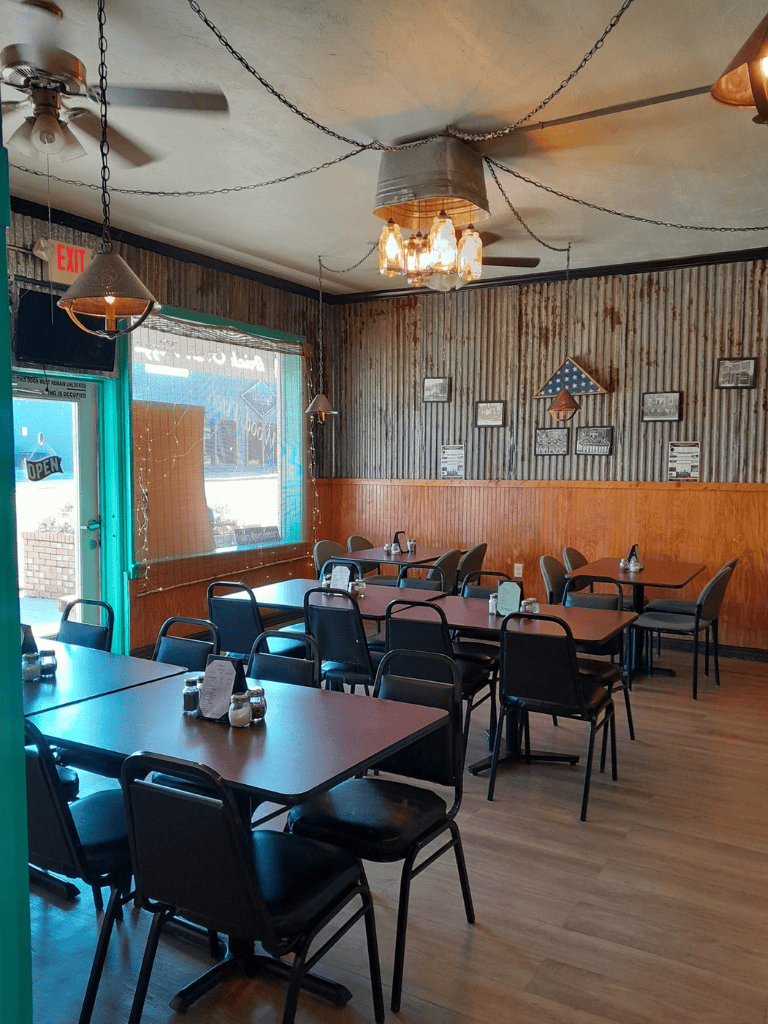 Outdoor casual dining restaurant, cozy interior with rustic decor, wooden walls, and American flags.