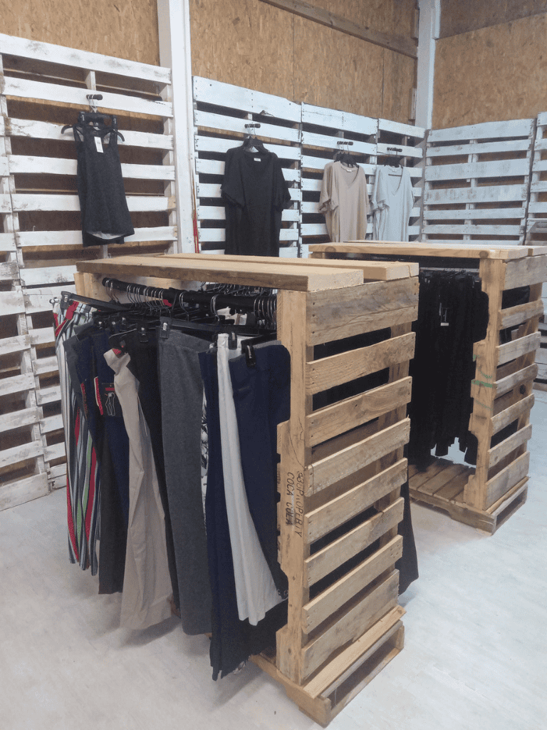 Clothing display at QuestForDirections consignment store, eco-friendly shopping option.