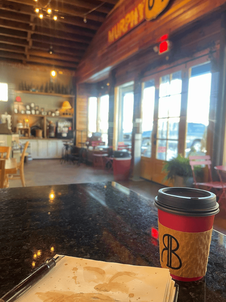 Cozy coffee shop interior with warm wood accents and sunlight, ideal for relaxing or working.
