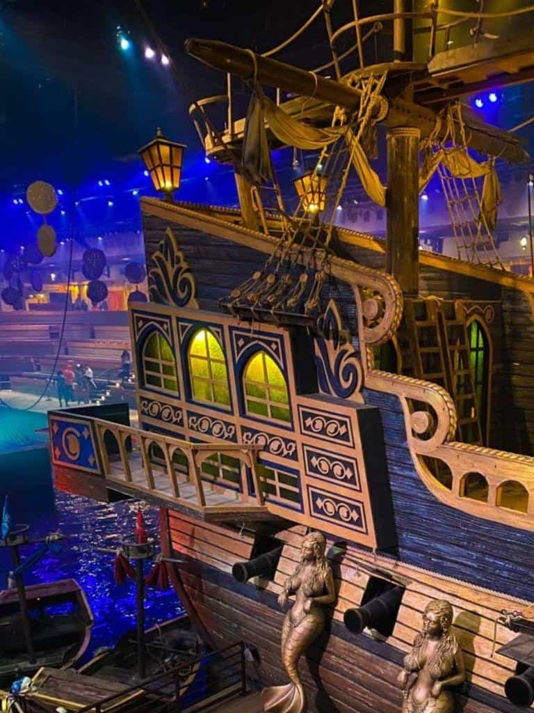 Colorful pirate ship replica with cannons at indoor entertainment venue.