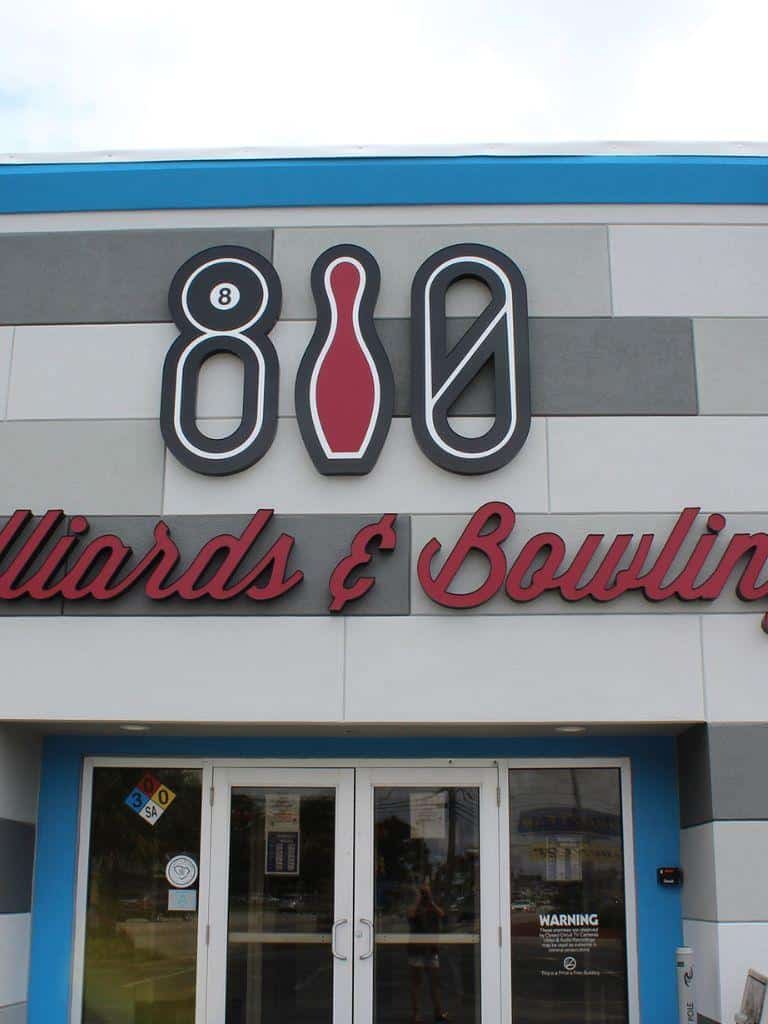 Eight ball, bowling alley, and lane symbols on building exterior.