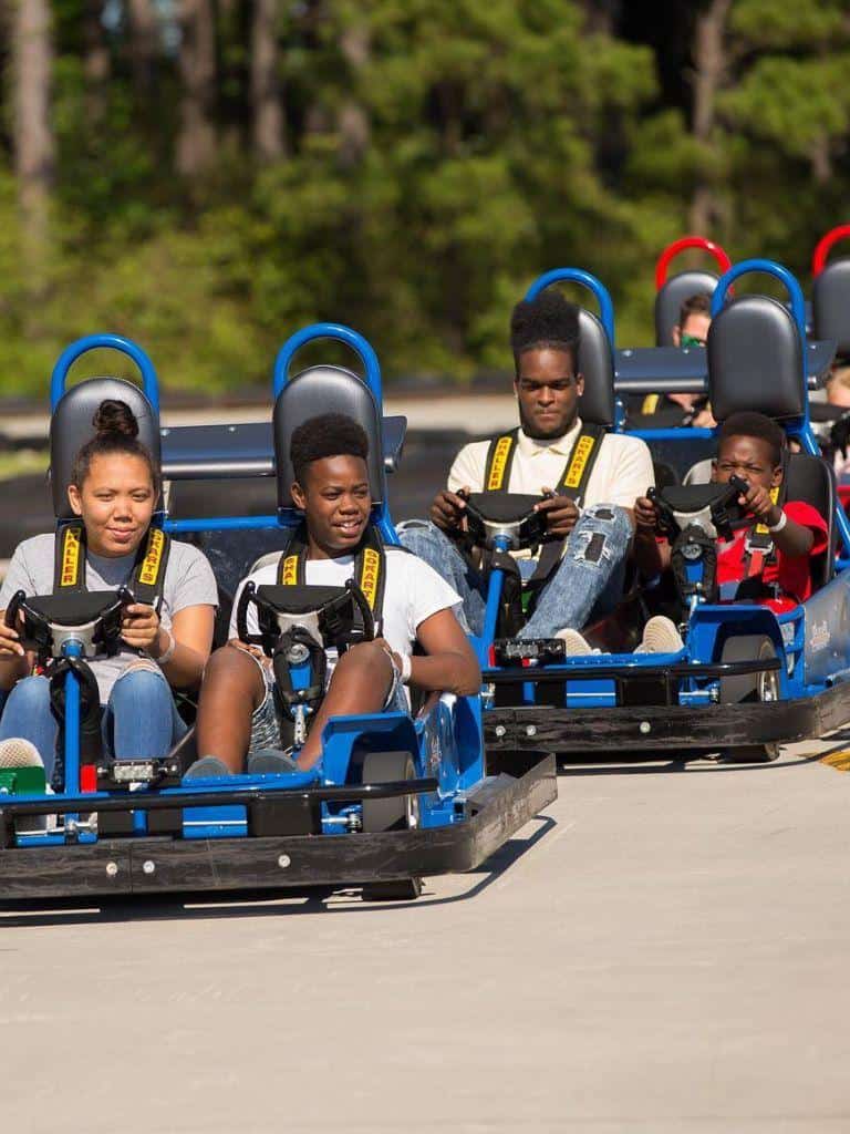 Thrill-seekers enjoying roller coaster ride at Quest for Directions amusement park. Fun and adventure for all ages.