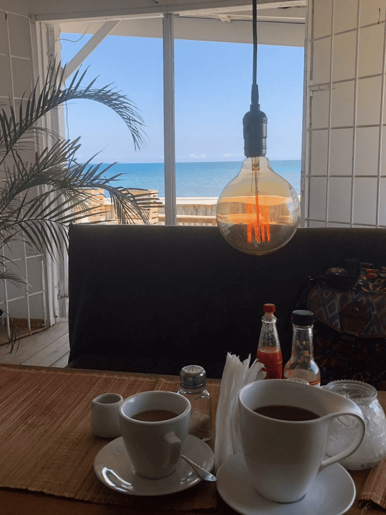 Beachside cafe with coffee, tea, and ocean view – perfect for relaxing mornings.
