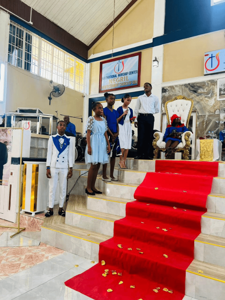 Children performing on church stage during a religious service at Negril International Worship Center.
