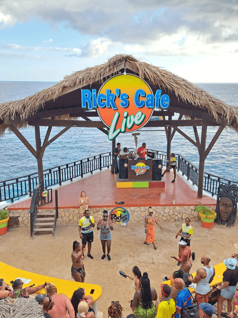 Relaxing oceanfront tiki hut at Rick's Cafe Live with live music and vibrant crowd.