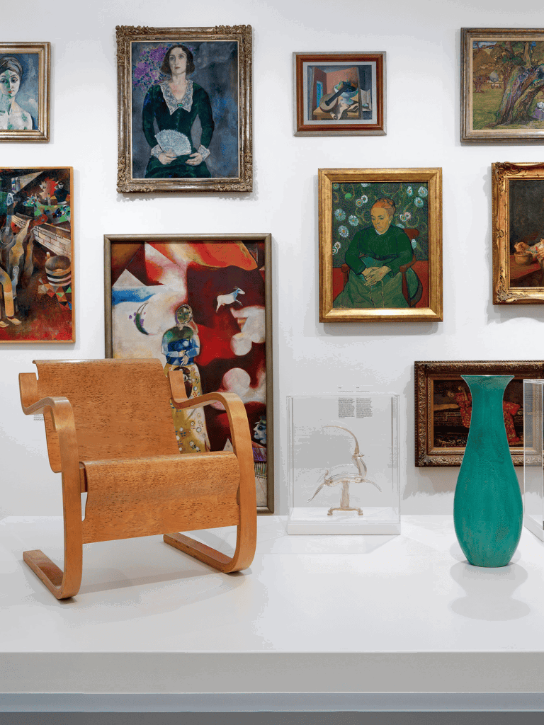 Colorful art gallery showcasing diverse paintings and sculptures with modern furniture displays.