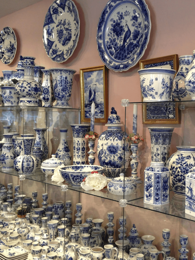 1. Blue and white porcelain pottery collection with vases, bowls, and decorative plates displayed on glass shelves.