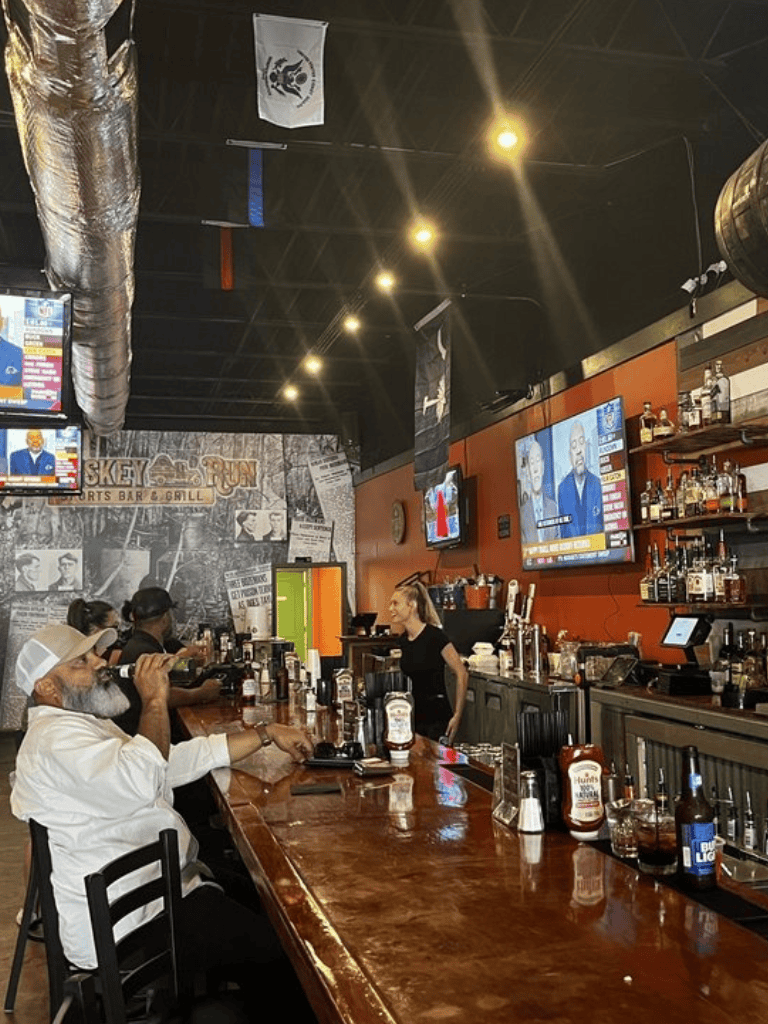 Craft beer bar with diverse patrons enjoying drinks at the lively sports bar ambiance.