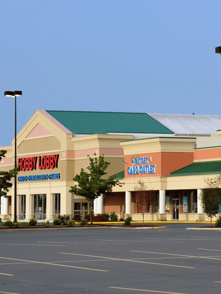 Bright shopping center with hobby lobby and card outlet stores in a spacious parking lot.