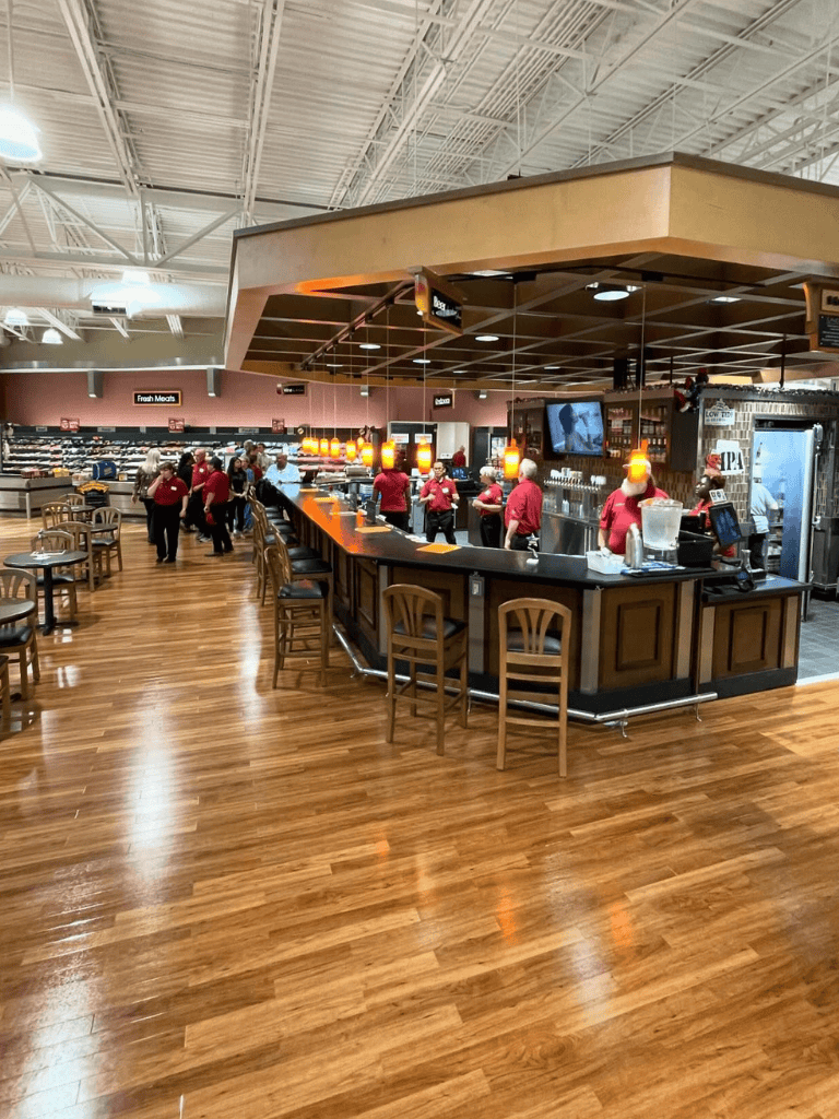 Fresh Meats section with a bar area at QuestForDirections grocery store, bustling with staff and customers.