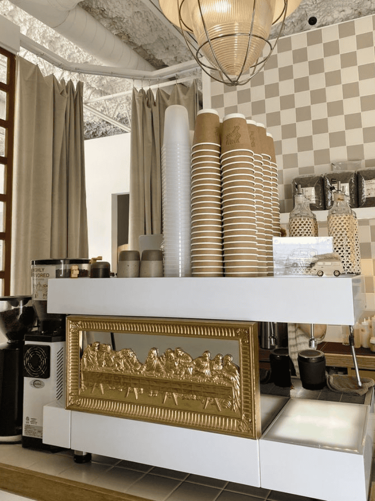 Disposable coffee cups stacked on a coffee machine at a cozy café.