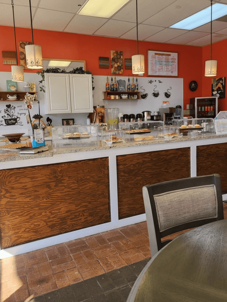 Cozy coffee shop interior with counter and pastries, QuestForDirections coffee shop welcoming ambiance.