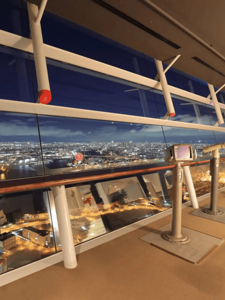 City skyline view from observation deck at Quest for Directions, high-rise downtown scenery, nighttime cityscape.