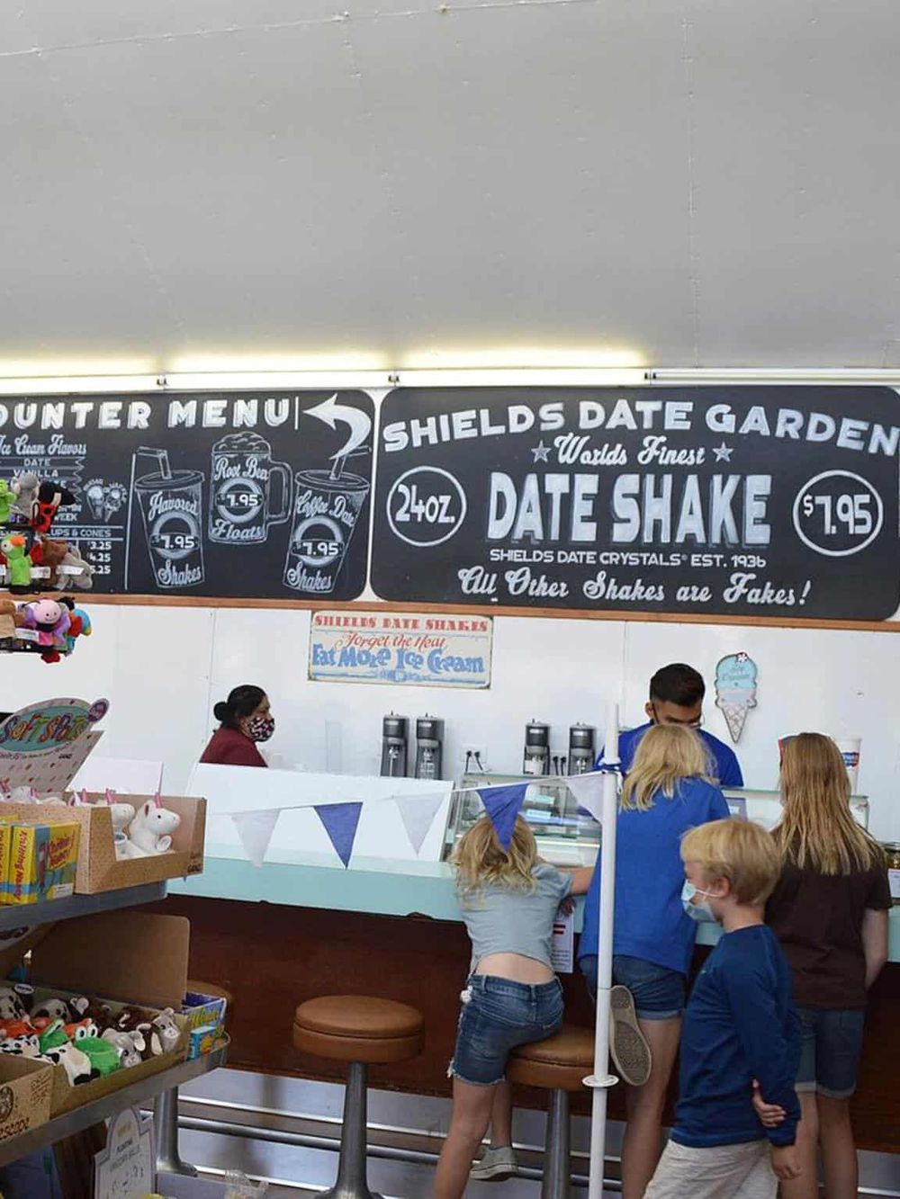 Colorful ice cream shop interior with customers ordering and enjoying treats.