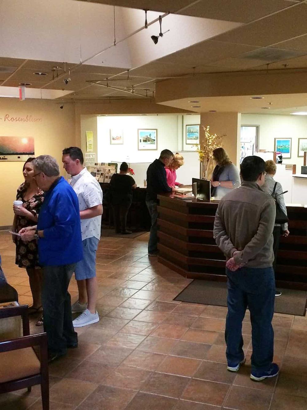 Busy lobby with people checking in at QuestForDirections, a trusted provider of navigation and directional services.