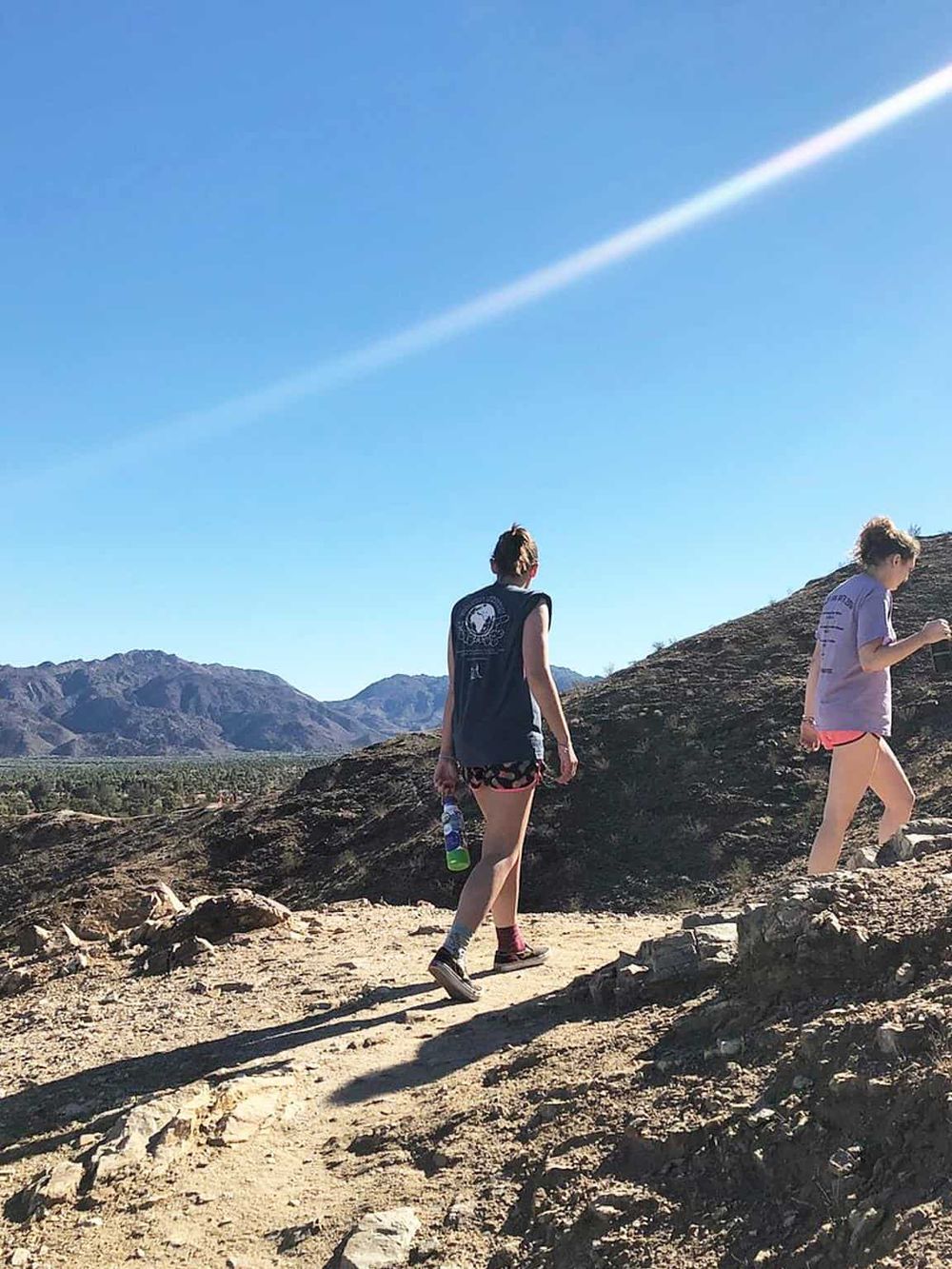 Kids hiking on desert trail with mountain view, outdoor adventure, exploration and nature experience.