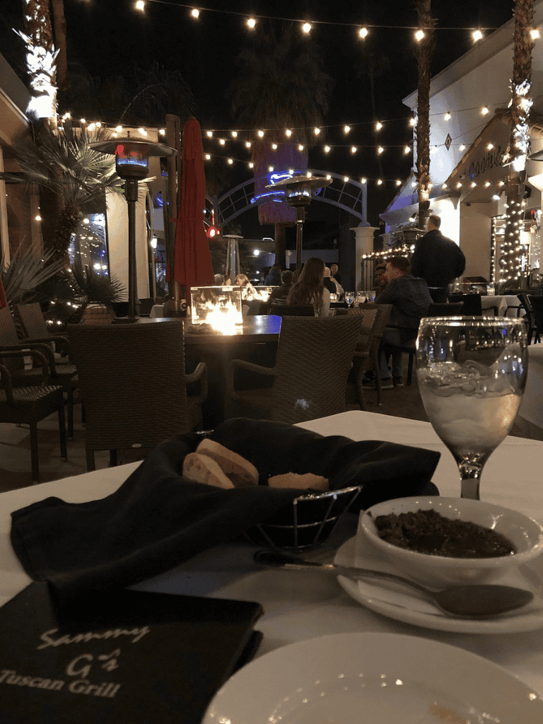 Relaxed outdoor dining at night with string lights and warm ambiance.