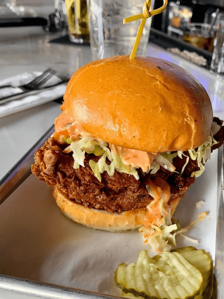 Crispy fried chicken sandwich with lettuce, spicy mayo, and pickles on a toasted bun. Perfect comfort food.