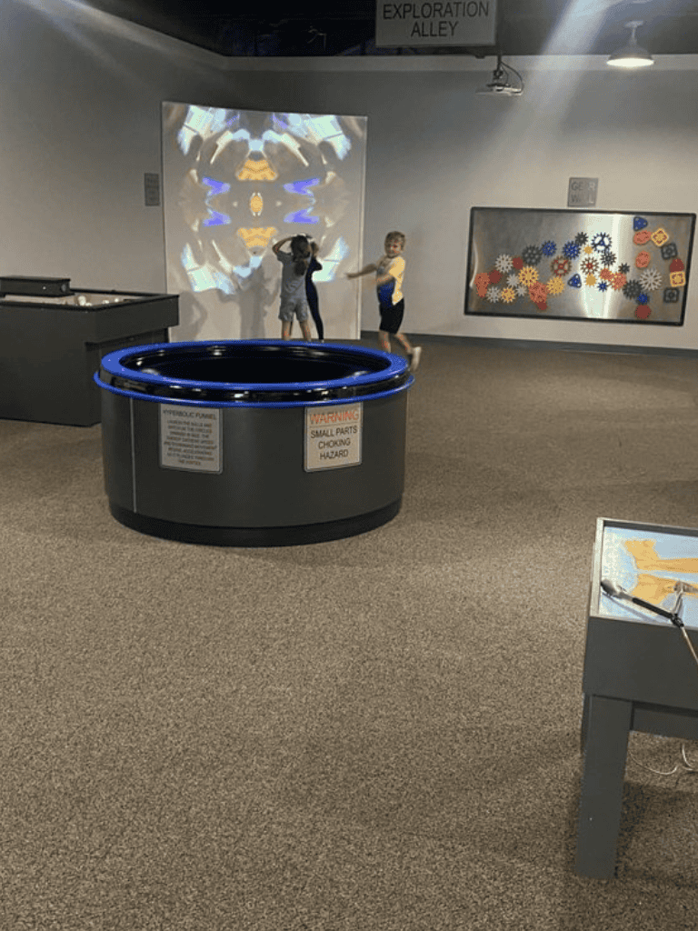 Colorful interactive exhibit with kids playing at QuestForDirections attraction.