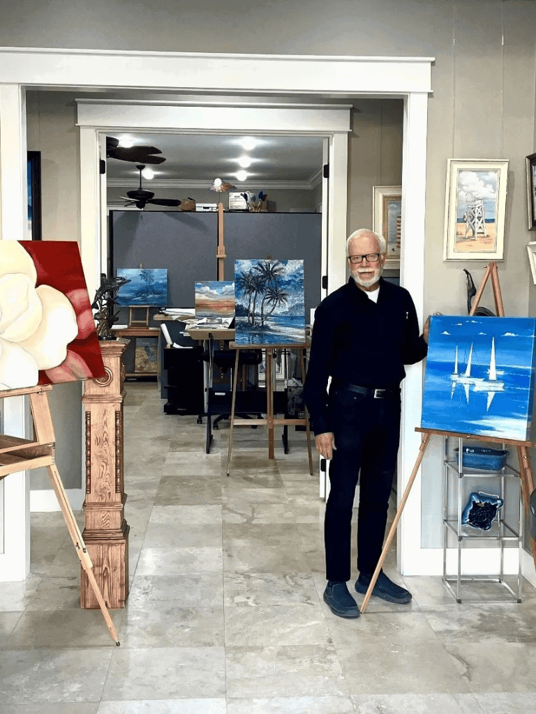 Vivid landscape painting of palm trees and ocean on canvas by artist in studio.