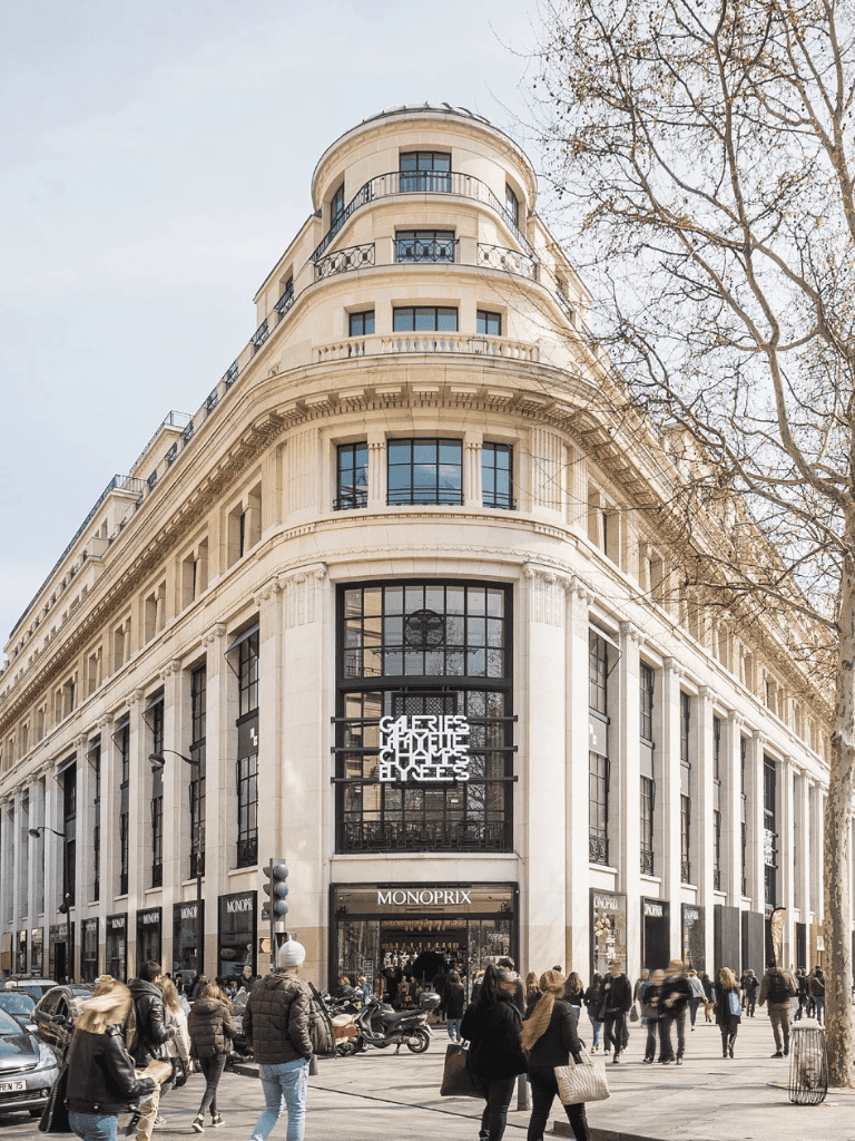 Modern high-end shopping mall with luxury retail stores on a busy city street corner.